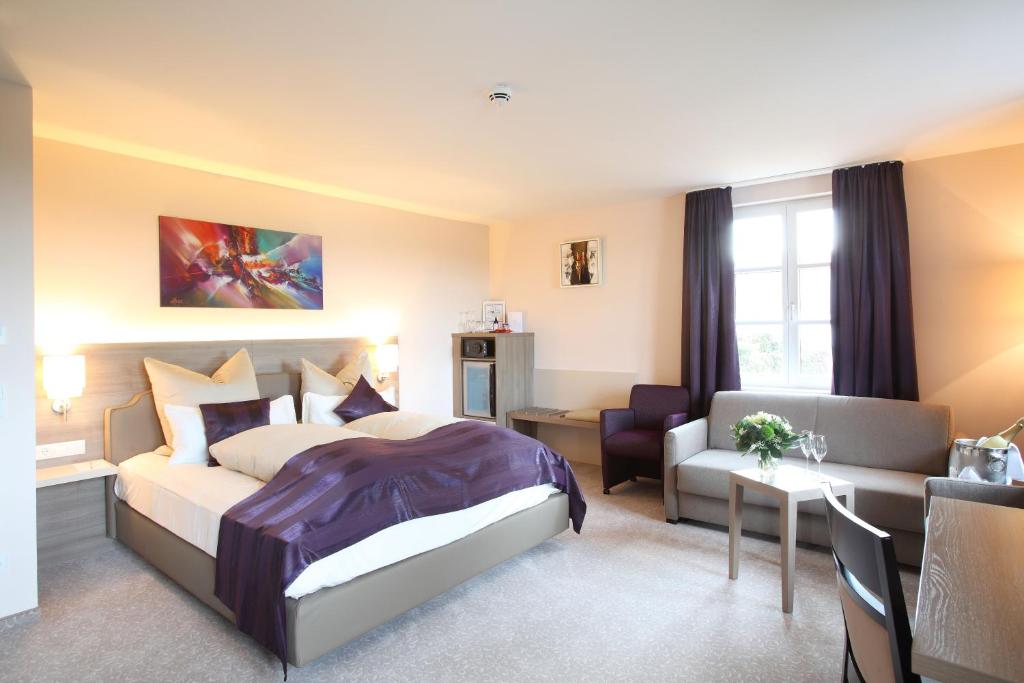 Zimmer im Hotel MainChateau Helles Doppelbett-Zimmer mit violetten Akzenten und zwei kleinen Sesseln im Hotel MainChateau Inh. Francesco Sorrentino