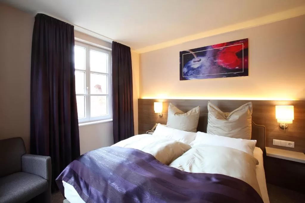 Zimmer im Hotel MainChateau Helles Doppelbett-Zimmer mit violetten Gardinen im Hotel MainChateau Inh. Francesco Sorrentino