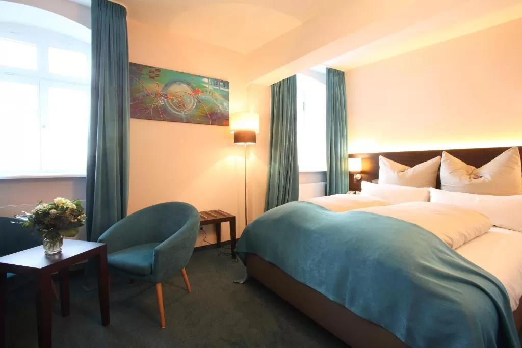 Zimmer im Hotel MainChateau Helles Doppelbett-Zimmer mit türkisen Gardinen im Hotel MainChateau Inh. Francesco Sorrentino